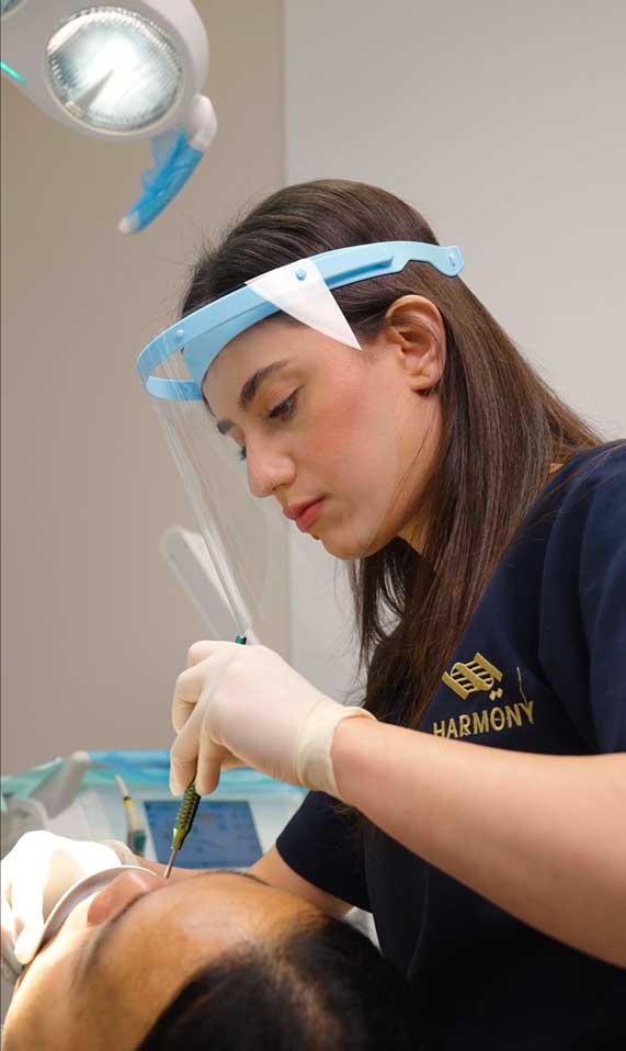 Female general dentist at Harmony Medical Center performing a routine dental checkup”
