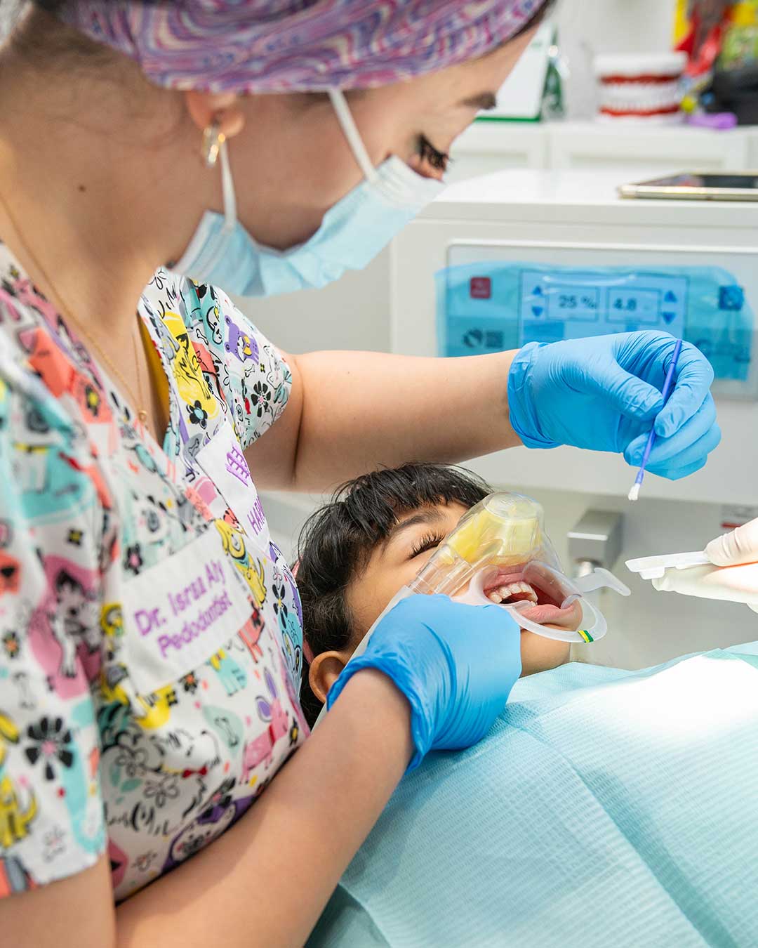 One of Harmony Medical Center’s pediatric dentists performing a fluoride treatment on a relaxed child.