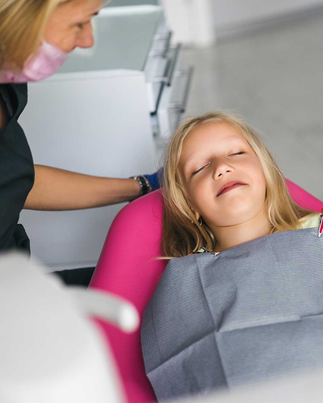 Young girl with her eyes closed relaxed during her dental treatment at Harmony Medical Center