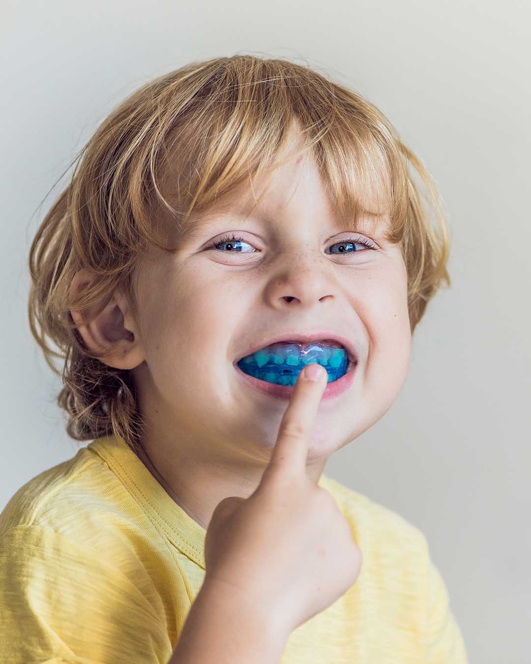 Cute young boy with a beautiful smile showing his myobrace appliance