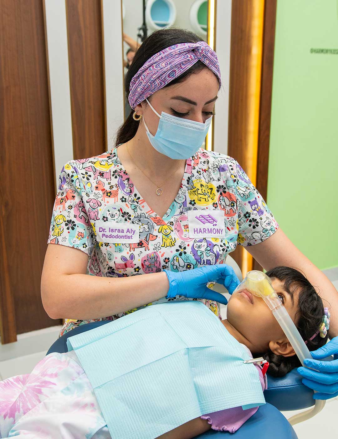 One of Harmony Medical Center’s pediatric dentists administering laughing gas to a young patient for a comfortable dental experience.